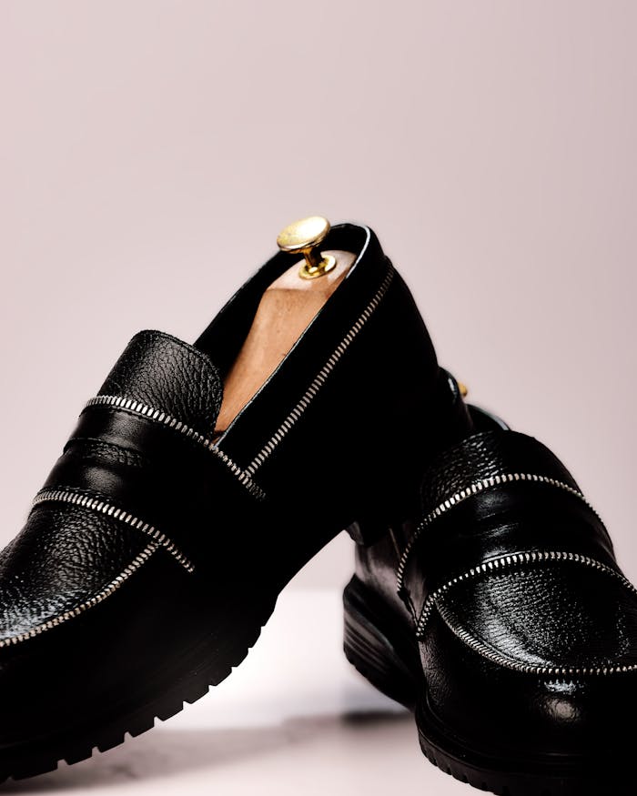 Stylish black leather loafers with gold accents for a classy, modern look.